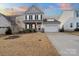 Two-story house with gray siding, stone accents, and a two-car garage at 117 Fairfield Dr, Troutman, NC 28166