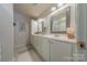 Double vanity bathroom with a large mirror and stylish fixtures at 12117 Frogs Leap Ct, Charlotte, NC 28277