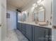 Elegant bathroom with double vanity, grey cabinets, and marble-look shower at 12117 Frogs Leap Ct, Charlotte, NC 28277