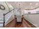 Open concept dining room with kitchen view, hardwood floors, and stylish light fixture at 12117 Frogs Leap Ct, Charlotte, NC 28277