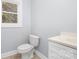 Clean bathroom with a toilet, vanity, and window at 12491 Oak Grove Rd, Stanfield, NC 28163