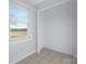 Bright laundry room features tile flooring and a window overlooking the backyard at 12491 Oak Grove Rd, Stanfield, NC 28163