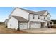 Side view of a two-story home, featuring a stone and white shingle facade and two-car garage at 13019 Arnold Palmer Cir # 832, Lancaster, SC 29720