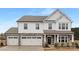 Charming two-story home with a stone and white shingle facade, two-car garage and covered front porch at 13019 Arnold Palmer Cir # 832, Lancaster, SC 29720