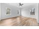 Bright bedroom featuring three large windows, ceiling fan, and light wood-look flooring at 1306 Eddie St, Gastonia, NC 28054