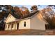 Newly constructed home with white siding, a covered porch and situated on a wooded lot at 1306 Eddie St, Gastonia, NC 28054