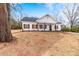 A charming, updated home with white siding, black roof, and wood accents and professionally landscaped front yard at 1306 Eddie St, Gastonia, NC 28054