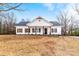 Charming exterior of a white, single-story home with a black roof and wooden columns accenting the front porch at 1306 Eddie St, Gastonia, NC 28054