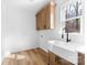 Bright laundry room with utility sink, cabinet space, and natural light from the window at 1306 Eddie St, Gastonia, NC 28054