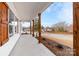 Covered porch with wooden post accents, concrete flooring, and well manicured landscaping at 1306 Eddie St, Gastonia, NC 28054