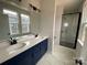 Modern bathroom features double vanity, white counters and subway tile shower with glass door at 1308 Walter Taylor Way # Eqx0105, Charlotte, NC 28206