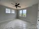 Spacious bedroom with light-colored walls, three windows, a ceiling fan, and white trim at 1308 Walter Taylor Way # Eqx0105, Charlotte, NC 28206