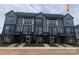 Modern townhome exterior featuring a sleek gray facade, large windows, and brick accents at 1308 Walter Taylor Way # Eqx0105, Charlotte, NC 28206