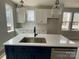 Bright kitchen features white cabinets, subway tile backsplash, quartz counters and a blue island with sink at 1308 Walter Taylor Way # Eqx0105, Charlotte, NC 28206