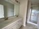 Bathroom featuring double sinks, a large mirror, and a glass-enclosed shower at 1611 Polk St # Eqx0209, Charlotte, NC 28206