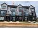 Modern townhome exterior with brick accents, black trim, balconies, and well-manicured landscaping at 1611 Polk St # Eqx0209, Charlotte, NC 28206
