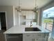 Bright kitchen featuring an island with quartz countertops, white cabinets, and stainless steel appliances at 1611 Polk St # Eqx0209, Charlotte, NC 28206