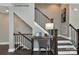 Staircase featuring a dark metal railing and wooden banister with a desk area on the landing at 1611 Polk St # Eqx0209, Charlotte, NC 28206