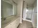 Bathroom featuring a double sink vanity with white cabinets and a glass-enclosed shower at 1615 Polk St # Eqx0208, Charlotte, NC 28206