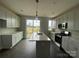 Open kitchen with island, stainless appliances, white cabinets, and a sliding glass door at 1615 Polk St # Eqx0208, Charlotte, NC 28206