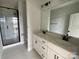 Bathroom featuring a double vanity, quartz countertop, and glass-enclosed shower at 1619 Polk St # Eqx0207, Charlotte, NC 28206