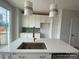 Gourmet kitchen featuring a large island with sink, stainless steel appliances and elegant pendant lighting at 1619 Polk St # Eqx0207, Charlotte, NC 28206