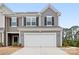 Two-story townhome with gray siding, white garage door, and landscaping at 2795 Yeager Nw Dr, Concord, NC 28027