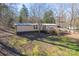 Mobile home exterior on a sloping lot with a yard at 3586 Bridle Path Dr, Vale, NC 28168