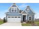 Two-story house with blue siding, white garage door, and landscaping at 40242 Crooked Stick Dr # 1198, Lancaster, SC 29720