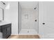 Bathroom with black fixtures, tiled shower, and white vanity at 613 Buffalo St, Shelby, NC 28150