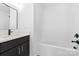 Bathroom featuring a single sink vanity, modern fixtures, and white tub at 613 Buffalo St, Shelby, NC 28150