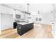 Modern kitchen featuring a black island, stainless appliances, and ample counter space, complemented by hardwood style floors at 613 Buffalo St, Shelby, NC 28150