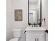 Modern bathroom with white vanity, black fixtures, and a frameless mirror at 10614 Arlington Church Rd, Charlotte, NC 28227