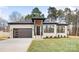 Stylish light brick home with a modern front door and landscaping at 10614 Arlington Church Rd, Charlotte, NC 28227