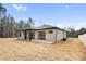 Rear view of a light brick house with covered patio and fenced yard at 10614 Arlington Church Rd, Charlotte, NC 28227