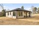 Rear view of a light brick house with a covered patio and grassy yard at 10614 Arlington Church Rd, Charlotte, NC 28227