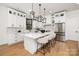 Modern kitchen with white cabinets, island with seating, and stainless steel appliances at 10614 Arlington Church Rd, Charlotte, NC 28227