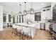 Modern kitchen with white cabinets, herringbone backsplash, and large island at 10614 Arlington Church Rd, Charlotte, NC 28227