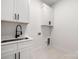 Bright laundry room with white cabinets and a modern sink at 10614 Arlington Church Rd, Charlotte, NC 28227