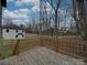 Wooden deck overlooking a spacious backyard with lawn, trees, and new fence, perfect for outdoor entertaining at 1304 Pleasant Plains Rd, Matthews, NC 28105