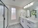 Contemporary bathroom with a double vanity, decorative mirror, and a glass-enclosed shower at 1304 Pleasant Plains Rd, Matthews, NC 28105