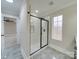 Modern bathroom features a sleek glass shower with black trim and gray tile flooring at 1304 Pleasant Plains Rd, Matthews, NC 28105