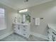 Bathroom features white cabinetry, gray tile flooring, framed mirror and black hardware at 1304 Pleasant Plains Rd, Matthews, NC 28105