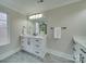 Bright bathroom features double sink with quartz countertops, white cabinets, and decorative mirror at 1304 Pleasant Plains Rd, Matthews, NC 28105