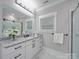 Modern bathroom with dual sinks, marble floors, and a glass-enclosed shower at 1304 Pleasant Plains Rd, Matthews, NC 28105