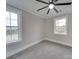 This bedroom features gray carpet, two windows and a ceiling fan at 1304 Pleasant Plains Rd, Matthews, NC 28105