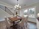 Bright dining room featuring hardwood floors, a chandelier, and large windows creating an inviting and cozy atmosphere at 1304 Pleasant Plains Rd, Matthews, NC 28105