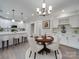 A dining room next to the kitchen features a round wood table, four upholstered chairs, and updated lighting at 1304 Pleasant Plains Rd, Matthews, NC 28105