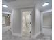 Hallway view of modern bathroom featuring gray tile, granite countertops, and white trim at 1304 Pleasant Plains Rd, Matthews, NC 28105