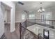 Open landing with wood floors, decorative railing, chandelier, and a view of the home's entry at 1304 Pleasant Plains Rd, Matthews, NC 28105